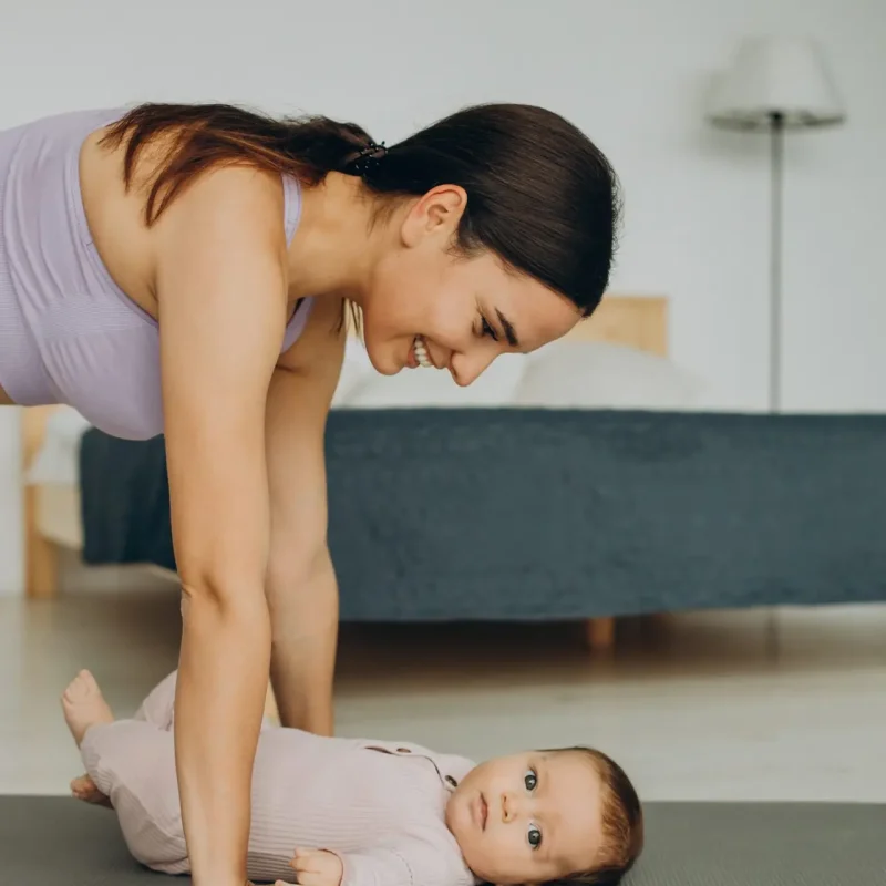 mother-with-her-baby-daughter-practice-yoga-home